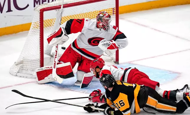 Pittsburgh Penguins' Justin Brazeau (16) gets a shot behind Carolina Hurricanes goaltender Frederik Andersen (31) for a goal with K'Andre Miller defending during the first period of an NHL hockey game in Pittsburgh, Tuesday, Dec. 30, 2025. (AP Photo/Gene J. Puskar)