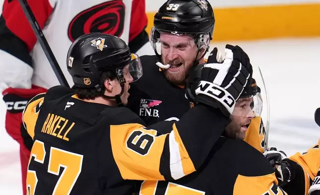 Pittsburgh Penguins' Anthony Mantha (39) celebrates his goal with Rickard Rakell (67) and Bryan Rust (17) during the first period of an NHL hockey game against the Carolina Hurricanes in Pittsburgh, Tuesday, Dec. 30, 2025. (AP Photo/Gene J. Puskar)