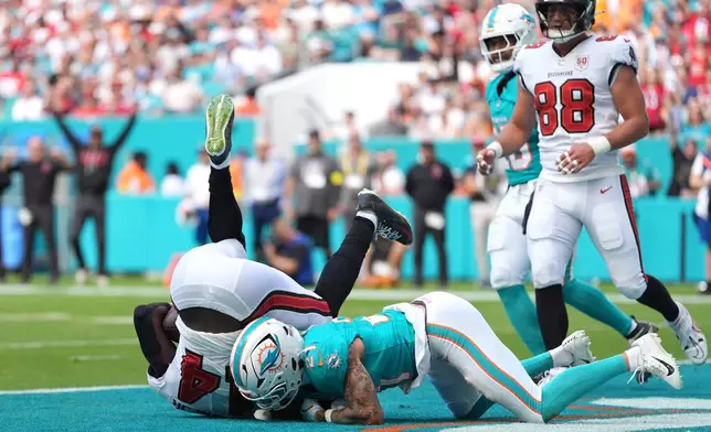 Tampa Bay Buccaneers wide receiver Chris Godwin Jr. (14) makes a catch for a touchdown against Miami Dolphins safety Ashtyn Davis (21) during the first half of an NFL football game Sunday, Dec. 28, 2025, in Miami Gardens, Fla. (AP Photo/Rebecca Blackwell)