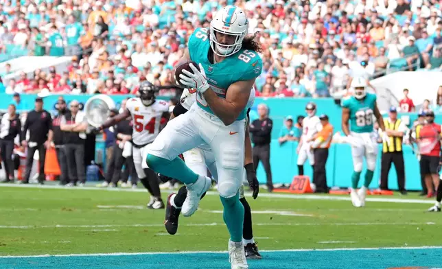 Miami Dolphins tight end Greg Dulcich (85) scores a touchdown against the Tampa Bay Buccaneers during the first half of an NFL football game Sunday, Dec. 28, 2025, in Miami Gardens, Fla. (AP Photo/Rebecca Blackwell)