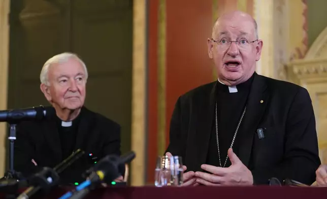 Outgoing archbishop of Westminster Vincent Nichols, left, listens to Bishop Richard Moth speaking during a press conference announcing him as the new Archbishop of Westminster, replacing Cardinal Vincent Nichols as the leader of the Catholic Church in England and Wales, in the Throne Room of Archbishop's House, Westminster, London, Friday Dec. 19, 2025. (Jonathan Brady/PA via AP)