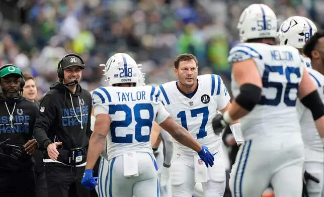 Indianapolis Colts quarterback Philip Rivers (17) and head coach Shane Steichen celebrate after a touchdown during the first half of an NFL football game against the Seattle Seahawks, Sunday, Dec. 14, 2025, in Seattle. (AP Photo/Stephen Brashear)
