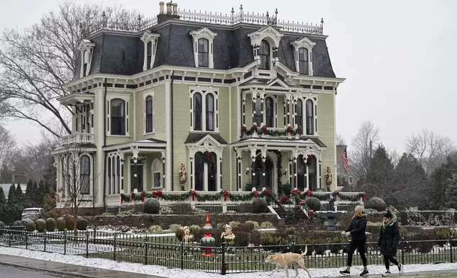 People walk by the Silas W Robbins B &amp; B in Wethersfield, Conn., Saturday, Dec. 6, 2025, where parts of the Hallmark film "Christmas on Honeysuckle Lane" was filmed. (AP Photo/Jessica Hill)