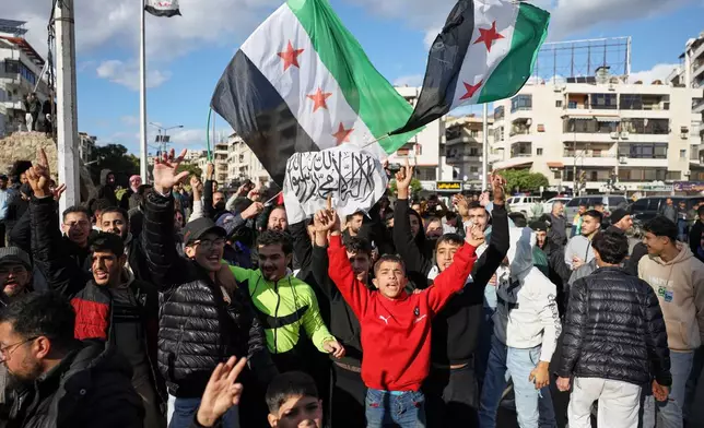 Counter-protesters chant pro-government slogans at Alawite demonstrators, two days after a bomb in an Alawite mosque in Homs killed eight people and wounded 18 during Friday prayers, in Latakia, Syria's coastal region, Sunday, Dec. 28, 2025. (AP Photo/Omar Albam)