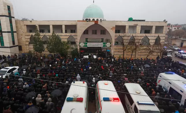 Mourners attend the funeral of victims of an attack a day earlier at the Imam Ali bin Abi Talib Mosque, outside the mosque in the predominantly Alawite Wadi al-Dhahab neighborhood of Homs, Syria, Saturday, Dec. 27, 2025. (AP Photo/Omar Sanadiki)