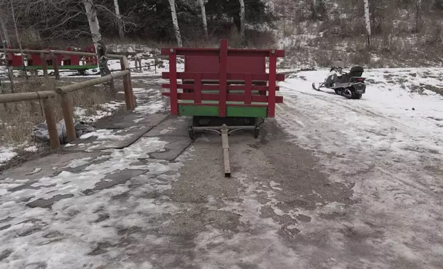 An sleigh rests by a stable, unable to be used with minimal snow cover Thursday, Dec. 18, 2025, in Edwards, Colo. (AP Photo/Brittany Peterson)