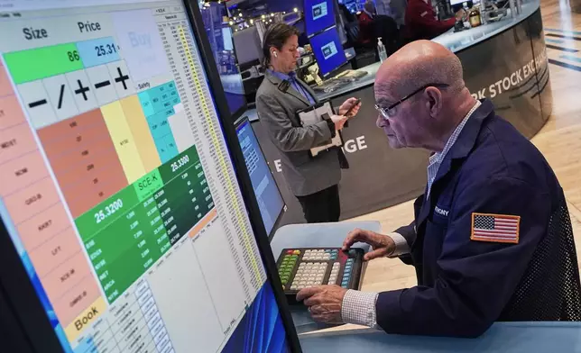 Trader Anthony Confusione works on the floor of the New York Stock Exchange, Thursday, Dec. 11, 2025. (AP Photo/Richard Drew)