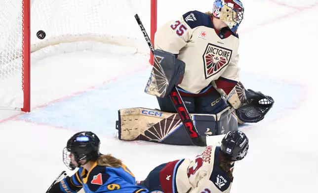 Toronto Sceptres' Daryl Watts (9) scores against Montreal Victoire goaltender Ann-Renee Desbiens (35) as Victoire's Erin Ambrose (23) tries to block the shot during the second period of a PWHL hockey game in Montreal, Saturday, Dec. 27, 2025. (Graham Hughes/The Canadian Press via AP)