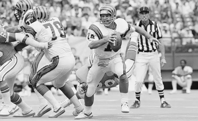 FILE - Cincinnati Bengals quarterback Ken Anderson scrambles out of the pocket and out of the grasp of a Houston Oiler defender during the fourth quarter of an NFL football game in Cincinnati, Sept. 13, 1982. (AP Photo/Ed Reinke, File)