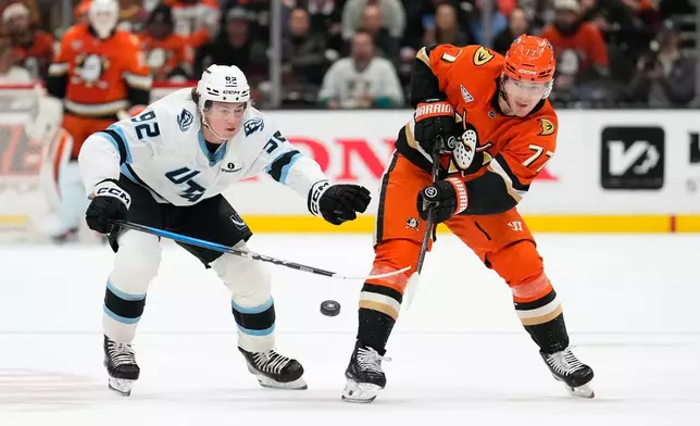 Anaheim Ducks right wing Frank Vatrano, right, passes the puck while under pressure from Utah Mammoth center Logan Cooley during the first period of an NHL hockey game Wednesday, Dec. 3, 2025, in Anaheim, Calif. (AP Photo/Mark J. Terrill)