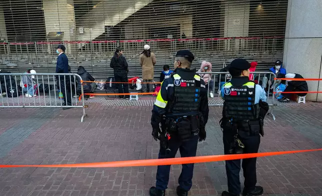 People wait to enter the West Kowloon Magistrates' Courts ahead of the verdict for Hong Kong activist publisher Jimmy Lai's national security trial, in Hong Kong, Monday, Dec. 15, 2025. (AP Photo/Chan Long Hei)