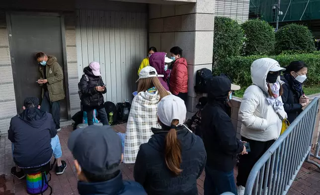 People wait to enter the West Kowloon Magistrates' Courts ahead of the verdict for Hong Kong activist publisher Jimmy Lai's national security trial, in Hong Kong, Monday, Dec. 15, 2025. (AP Photo/Chan Long Hei)