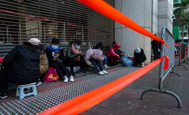 People wait to enter the West Kowloon Magistrates' Courts ahead of the verdict for Hong Kong activist publisher Jimmy Lai's national security trial, in Hong Kong, Monday, Dec. 15, 2025. (AP Photo/Chan Long Hei)
