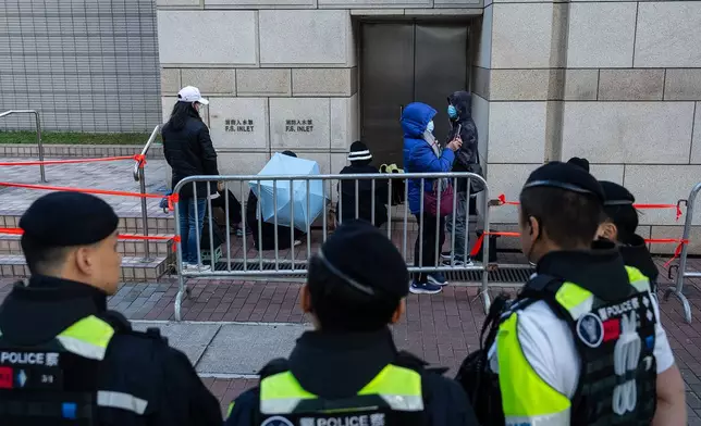 People wait to enter the West Kowloon Magistrates' Courts ahead of the verdict for Hong Kong activist publisher Jimmy Lai's national security trial, in Hong Kong, Monday, Dec. 15, 2025. (AP Photo/Chan Long Hei)