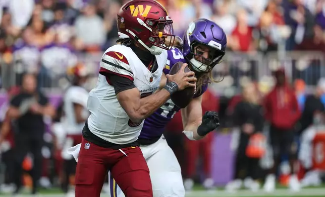 Washington Commanders quarterback Jayden Daniels (5) looks to pass while being chased by Minnesota Vikings linebacker Andrew Van Ginkel (43) during the first half of an NFL football game, Sunday, Dec. 7, 2025, in Minneapolis. (AP Photo/Matt Krohn)