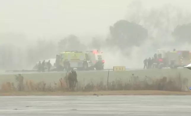 This screengrab made from video provided by WSOC shows firefighting crews responding to a reported plane crash at a regional airport in Statesville, N.C., erupting in a large fire, Thursday, Dec. 8, 2025. (WSOC via AP)