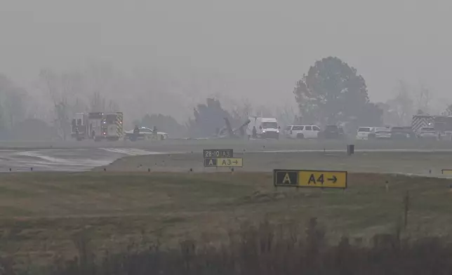 First responders tend to the scene of a reported plane crash at a regional airport in Statesville, N.C., Thursday, Dec. 18, 2025. (AP Photo/Matt Kelley)