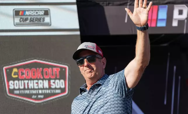 FILE - Former driver Greg Biffle waves to fans prior to a NASCAR Cup Series auto race at Darlington Raceway, Aug. 31, 2025, in Darlington, S.C. (AP Photo/Matt Kelley, File)
