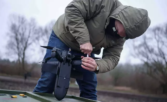 A serviceman prepares an interceptor drone of "General Cherry" company before a flight at the polygon in Ukraine, on Dec. 4, 2025. (AP Photo/Evgeniy Maloletka)
