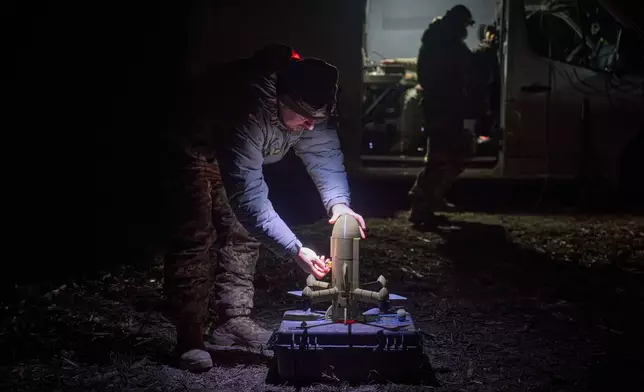 A Ukrainian soldier prepares an interceptor drone during Russia's aerial attack in an undisclosed location in Ukraine, on Dec. 13, 2025. (AP Photo/Efrem Lukatsky)