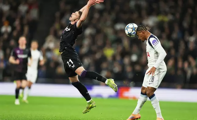 Slavia's David Doudera, left, grimaces as Tottenham's Wilson Odobert heads the ball during the Champions League opening phase soccer match between Tottenham and Slavia Prague, in London, England, Tuesday, Dec. 9, 2025. (AP Photo/Richard Pelham)