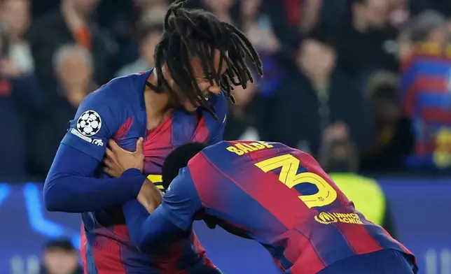 Barcelona's Jules Kounde left, celebrates with Alejandro Balde after scoring his side's second goal during the Champions League opening phase soccer match between Barcelona and Eintracht Frankfurt in Barcelona, Spain, Tuesday, Dec. 9, 2025. (AP Photo/Joan Monfort)