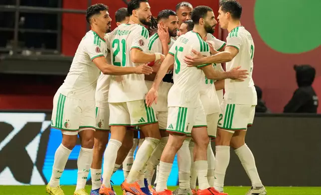 Algeria's Riyad Karim Mahrez, center, celebrates with his teammates after scoring his side's first goal during the Africa Cup of Nations group E soccer match between Algeria and Burkina Faso in Fez, Morocco, Sunday, Dec. 28, 2025. (AP Photo/Mosa'ab Elshamy)