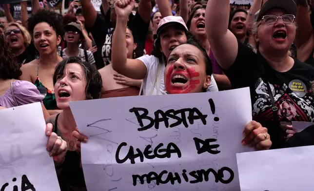 A demonstrator holds up a sign that reads in Portuguese, "Enough! Enough of machismo," during a march against femicide following a series of high-profile cases in the country, in Sao Paulo, Sunday, Dec. 7, 2025. (AP Photo/Ettore Chiereguini)
