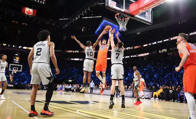Oklahoma City Thunder center Chet Holmgren (7) jumps up for a shot near San Antonio Spurs' Harrison Barnes (40) and Luke Kornet (7) in the first half of an NBA Cup semifinals basketball game, Saturday, Dec. 13, 2025, in Las Vegas. (AP Photo/Ronda Churchill)
