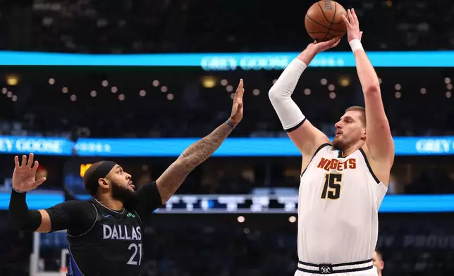 Denver Nuggets center Nikola Jokic (15) shoots over Dallas Mavericks forward Daniel Gafford (21) during the first quarter of an NBA basketball game Tuesday, Dec. 23, 2025, in Dallas. (AP Photo/Sam Hodde)