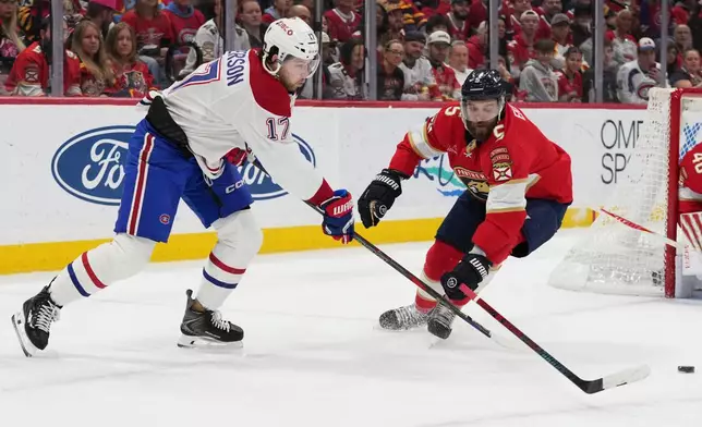 Montréal Canadiens right wing Josh Anderson (17) passes the puck as Florida Panthers defenseman Aaron Ekblad (5) defends during the first period of an NHL hockey game, Tuesday, Dec. 30, 2025, in Sunrise, Fla. (AP Photo/Lynne Sladky)