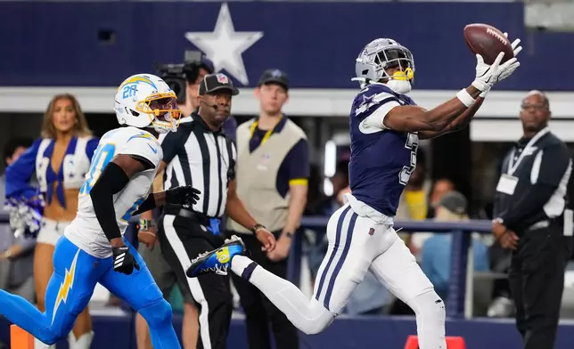 Dallas Cowboys wide receiver George Pickens (3) makes a touchdown catch past Los Angeles Chargers cornerback Cam Hart (20) during the first half of an NFL football game Sunday, Dec. 21, 2025, in Arlington, Texas. (AP Photo/Tony Gutierrez)