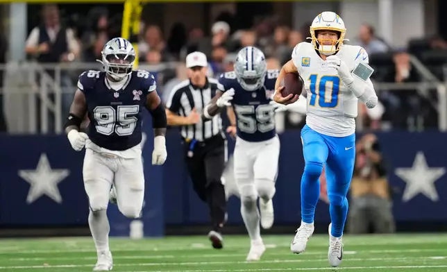 Los Angeles Chargers quarterback Justin Herbert (10) runs during the second half of an NFL football game against the Dallas Cowboys, Sunday, Dec. 21, 2025, in Arlington, Texas. (AP Photo/Tony Gutierrez)