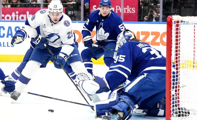 Tampa Bay Lightning right wing Pontus Holmberg, left, looks to shoot on Toronto Maple Leafs goaltender Dennis Hildeby, rigjht, during the first period of an NHL hockey game in Toronto, Monday, Dec. 8, 2025. (Chris Young/The Canadian Press via AP)