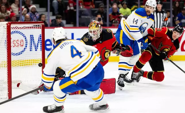Buffalo Sabres' Bowen Byram (4) scores on Ottawa Senators goaltender Linus Ullmark (35) during first period NHL hockey action in Ottawa, on Tuesday, Dec. 23, 2025. (Spencer Colby/The Canadian Press via AP)