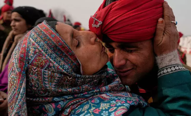 The mother of a newly graduated soldier of the Jammu and Kashmir Light Infantry (JKLI) Regiment kisses her son during a passing out parade at a training center on the outskirts of Srinagar, Indian-controlled Kashmir, Thursday, Dec. 4, 2025. (AP Photo/Mukhtar Khan)