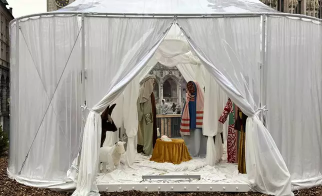 A Nativity scene containing characters with cloth faces, by Belgian artist Victoria-Maria Geyer, is displayed in a white tent in Brussels, Monday, Dec. 1, 2025. (AP Photo/Sylvain Plazy)