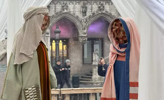 A Nativity scene containing characters with cloth faces, by Belgian artist Victoria-Maria Geyer, is displayed in a white tent in Brussels, Monday, Dec. 1, 2025. (AP Photo/Sylvain Plazy)