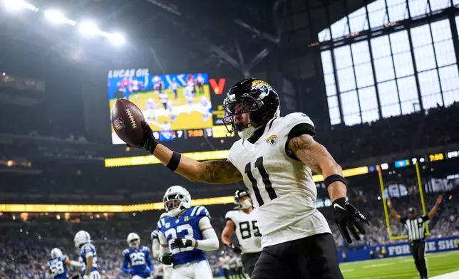 Jacksonville Jaguars wide receiver Parker Washington (11) celebrates after a catch and run during the second half of an NFL football game against the Indianapolis Colts Sunday, Dec. 28, 2025, in Indianapolis. (AP Photo/Carolyn Kaster)
