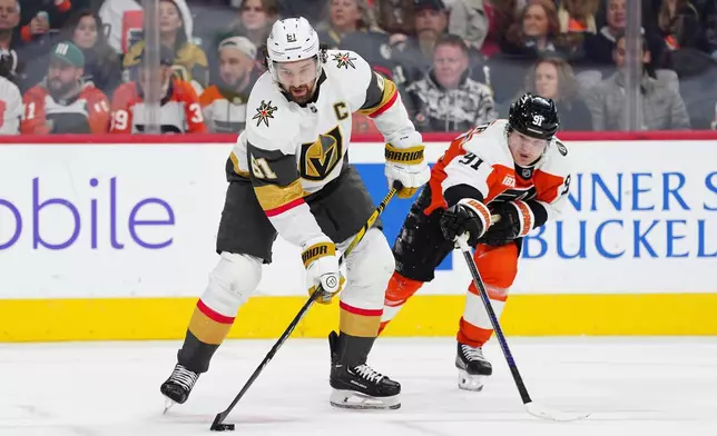 Vegas Golden Knights' Mark Stone (61) plays the puck past Philadelphia Flyers' Carl Grundstrom during the third period of an NHL hockey game, Thursday, Dec. 11, 2025, in Philadelphia. (AP Photo/Derik Hamilton)