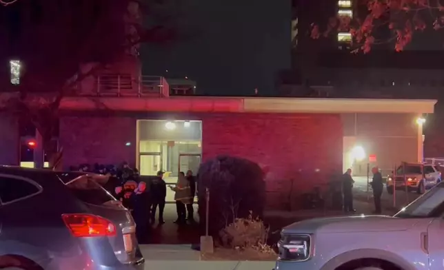 In this image from video, law enforcement officials gather outside the Brown University campus in Providence, R.I., on Saturday, Dec. 13, 2025. (AP Photo/Kimberlee Kruesi)