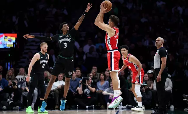 Los Angeles Clippers guard Bogdan Bogdanovic, right, shoots the ball as Minnesota Timberwolves forward Jaden McDaniels (3) defends during the first half of an NBA basketball game Saturday, Dec. 6, 2025, in Minneapolis. (AP Photo/Matt Krohn)