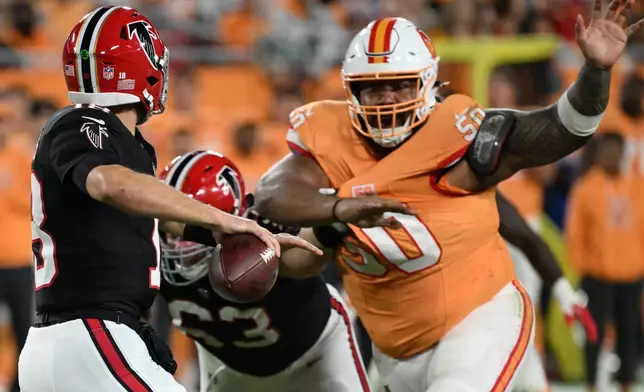 Atlanta Falcons quarterback Kirk Cousins (18) passes against Tampa Bay Buccaneers defensive tackle Vita Vea (50) during the first half of an NFL football game, Thursday, Dec. 11, 2025, in Tampa, Fla. (AP Photo/Jason Behnken)