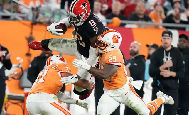 Atlanta Falcons tight end Kyle Pitts Sr. (8) leaps over Tampa Bay Buccaneers safety Christian Izien (29) during the first half of an NFL football game, Thursday, Dec. 11, 2025, in Tampa, Fla. (AP Photo/Chris O'Meara)