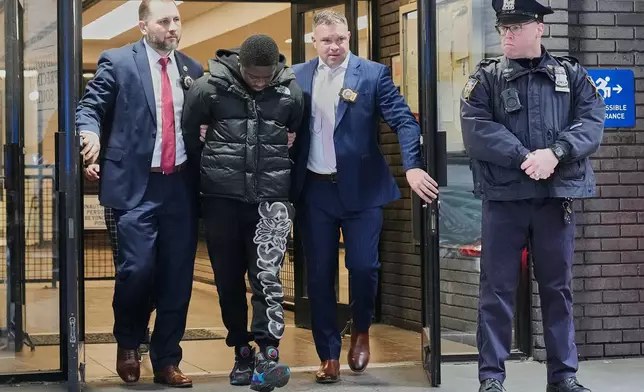Frederick Green, 20, of The Bronx borough of New York, charged with attempted murder in the shooting of New York Jets' player Kris Boyd, is escorted from the Midtown South Police Precinct, in New York, Tuesday, Dec. 9, 2025. (AP Photo/Richard Drew)