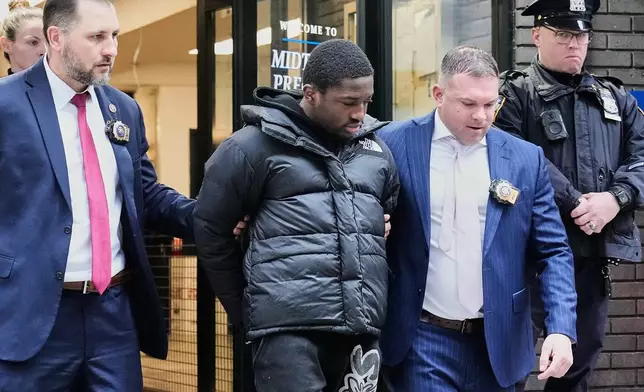 Frederick Green, 20, of The Bronx borough of New York, charged with attempted murder in the shooting of New York Jets' player Kris Boyd, is escorted from the Midtown South Police Precinct, in New York, Tuesday, Dec. 9, 2025. (AP Photo/Richard Drew)