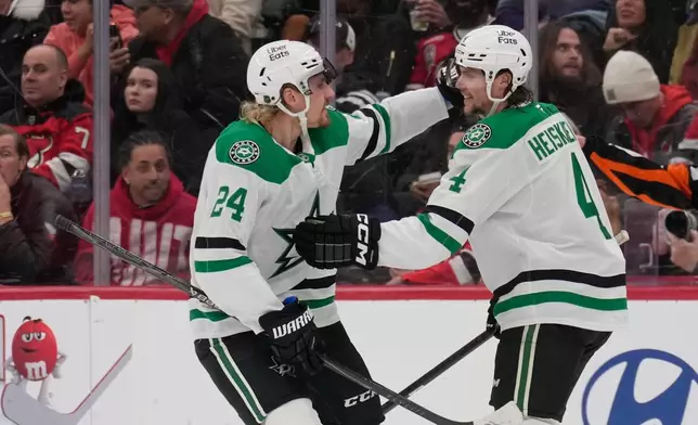 Dallas Stars' Miro Heiskanen, right, celebrates his goal with Roope Hintz during the second period of an NHL hockey game against the New Jersey Devils in Newark, N.J., Wednesday, Dec. 3, 2025. (AP Photo/Seth Wenig)