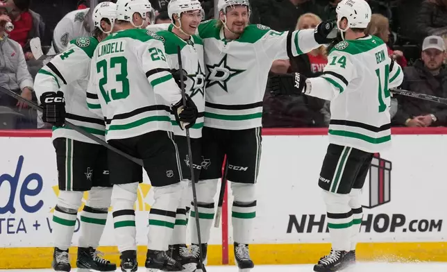 Dallas Stars' Jason Robertson, center, celebrates with teammates after scoring during the second period of an NHL hockey game against the New Jersey Devils in Newark, N.J., Wednesday, Dec. 3, 2025. (AP Photo/Seth Wenig)