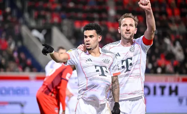 Bayern's Luis Díaz, left, celebrates with Harry Kane after scoring their side's third goal of the game during the Bundesliga soccer match between FC Heidenheim and Bayern Munich, in Heidenheim, Germany, Sunday Dec. 21, 2025. (Harry Langer/dpa via AP)