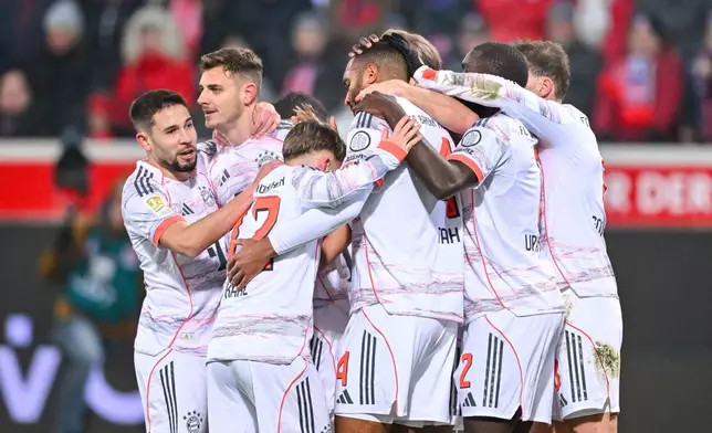 Bayern's Josip Stanisic celebrates with teammates after scoring their side's first goal of the game during the Bundesliga soccer match between FC Heidenheim and Bayern Munich, in Heidenheim, Germany, Sunday Dec. 21, 2025. (Harry Langer/dpa via AP)